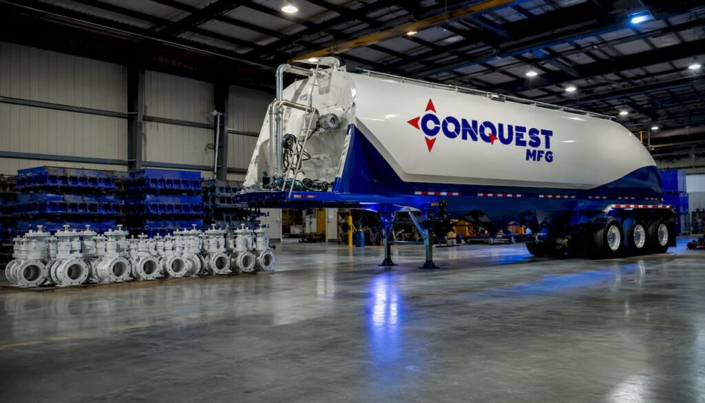 Cement storage pig guppy trailer in warehouse with company logo