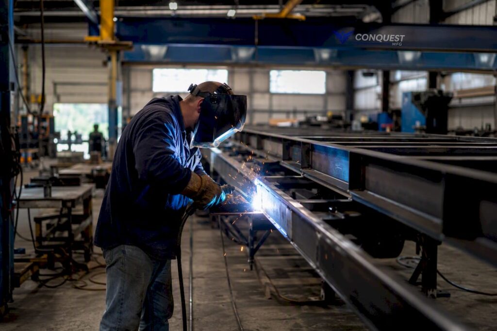 Worker welding custom trailer frame